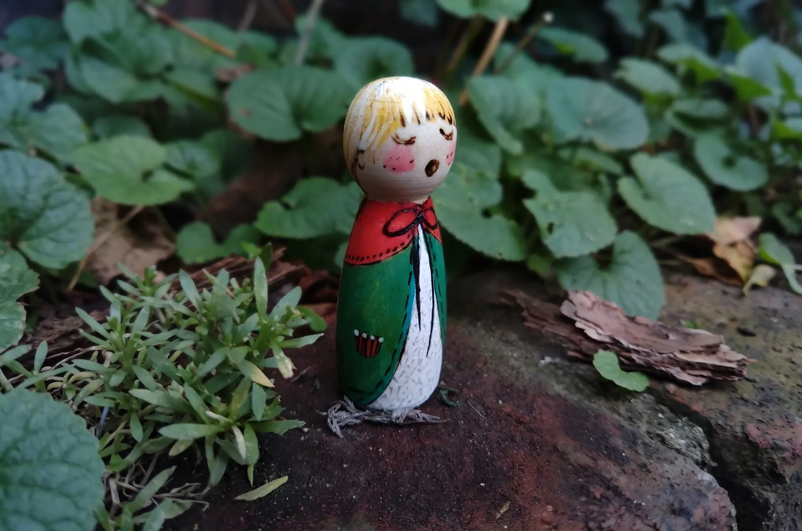Fijn bewerkt en met de hand beschilderd houten winterpopje dat buiten een lied lijkt te zingen. Een sfeervolle, handgemaakte peg doll die zorgt voor een vredig winters accent in de kinderkamer of op de seizoenstafel.